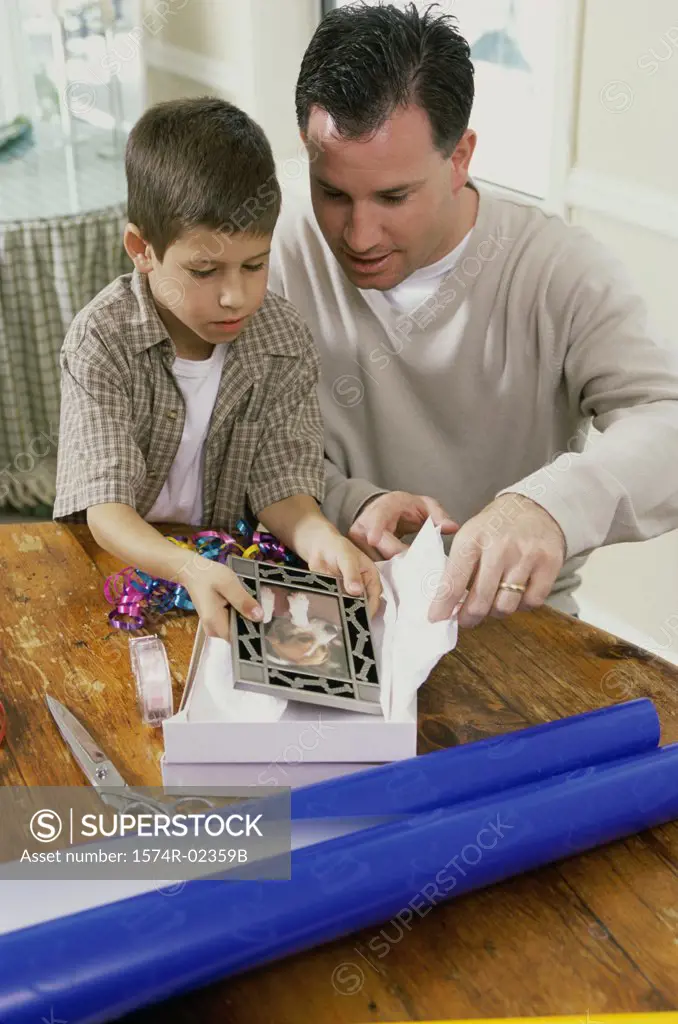 Father and son wrapping a gift