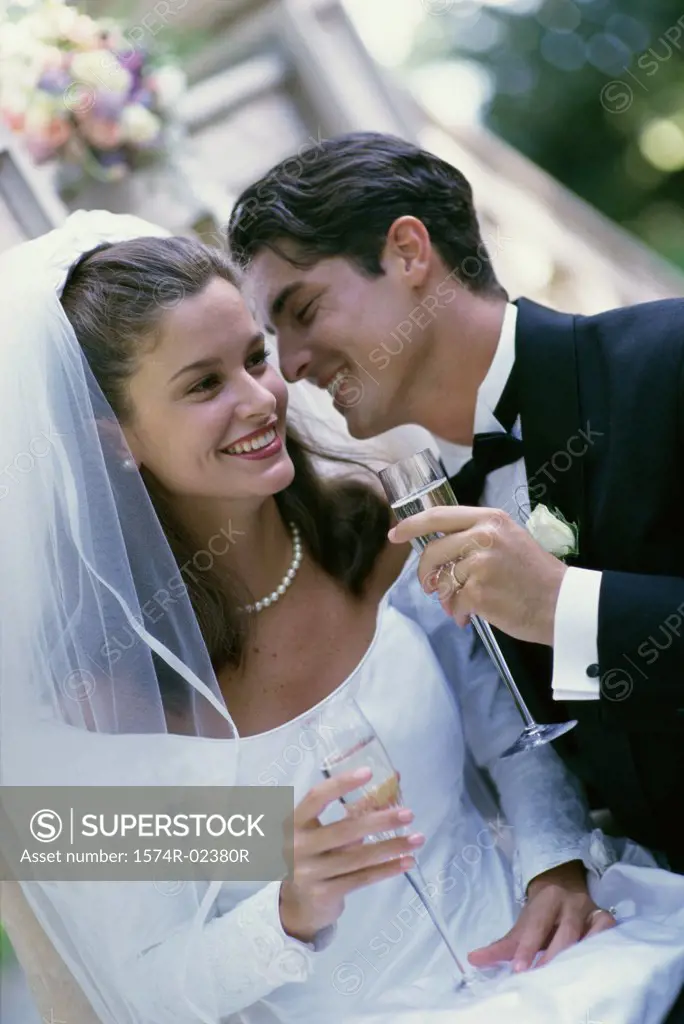 Newlywed couple smiling while holding glasses of champagne