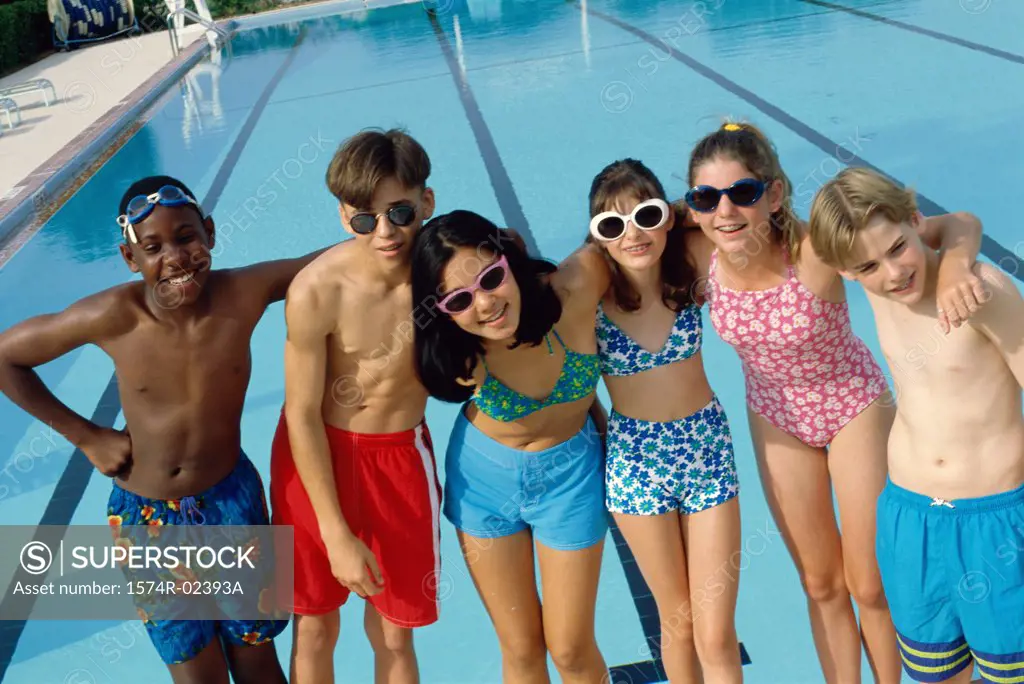 Portrait of a group of teenagers standing beside a swimming pool