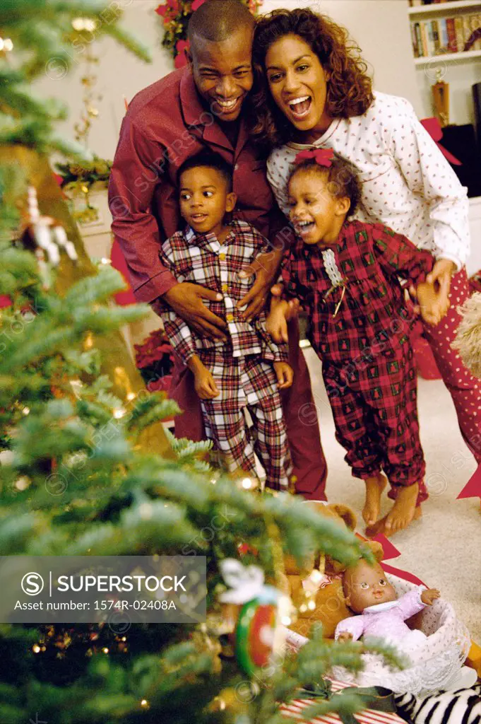 Parents with their son and daughter near a Christmas tree