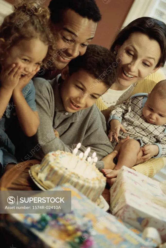 Parents with their children in front of a birthday cake