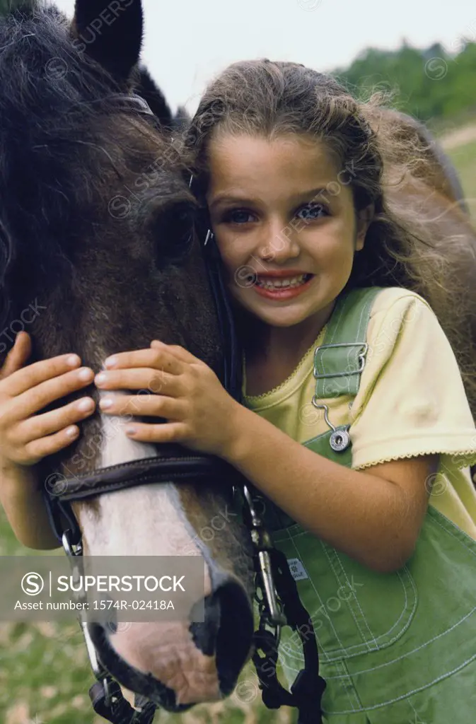 Portrait of a girl standing with a horse