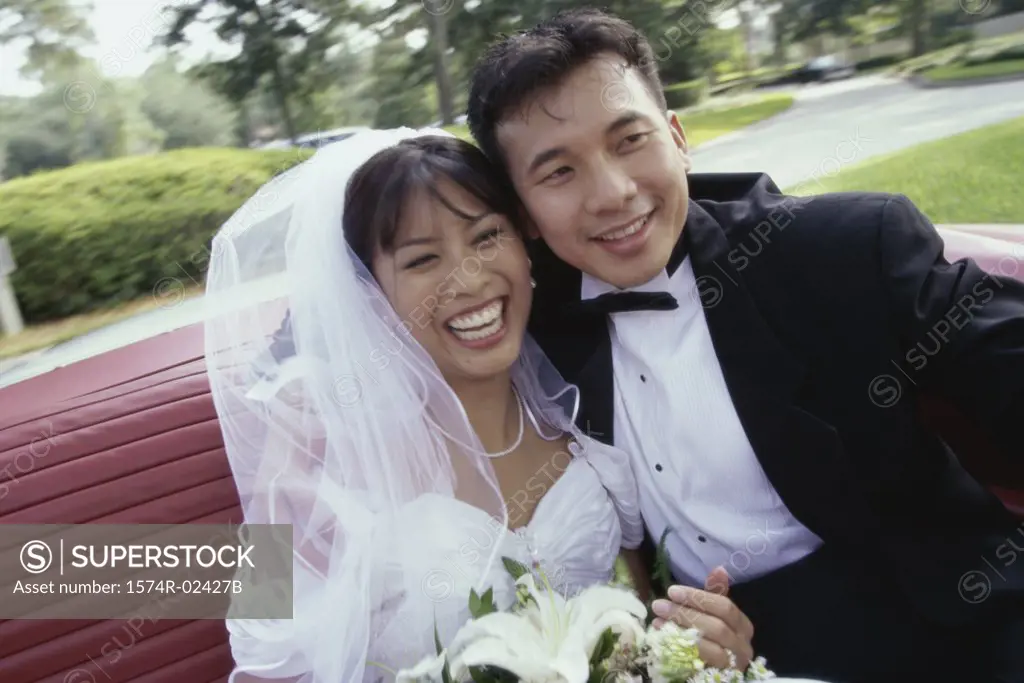 Newlywed couple sitting in a convertible car