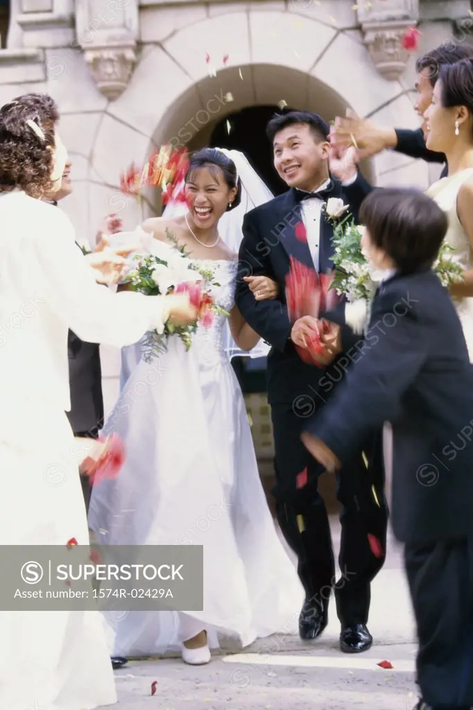 Flower petals being thrown on a bride and groom