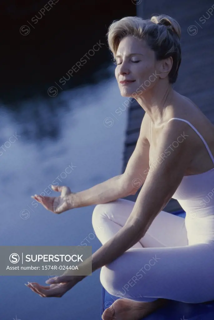 Side profile of a mid adult woman meditating