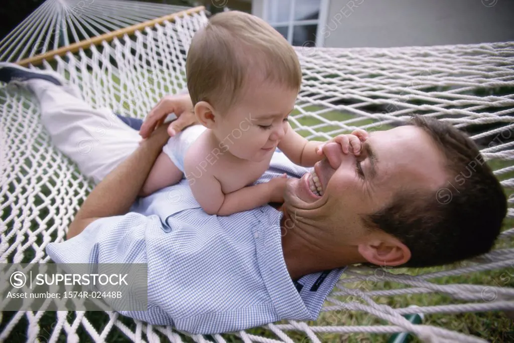 Father lying in a hammock with his baby boy