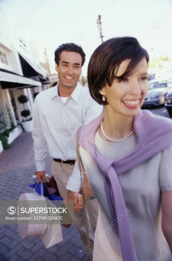 Mid adult couple carrying shopping bags