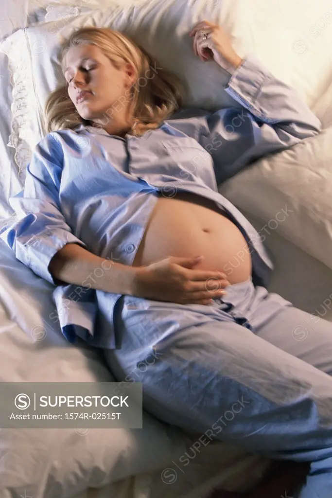 High angle view of a pregnant woman sleeping on a bed