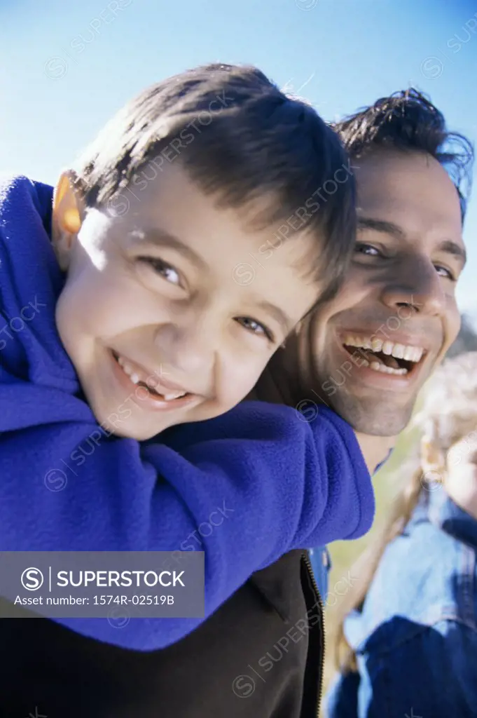 Close-up of a son riding piggyback on his father