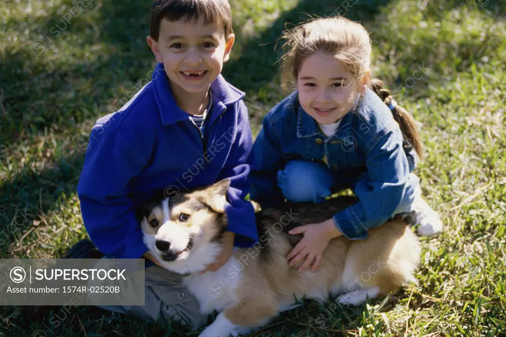 High angle view of a boy and a girl petting their dog