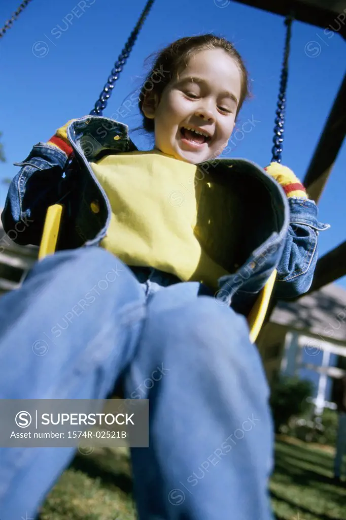 Low angle view of a girl sitting on a swing