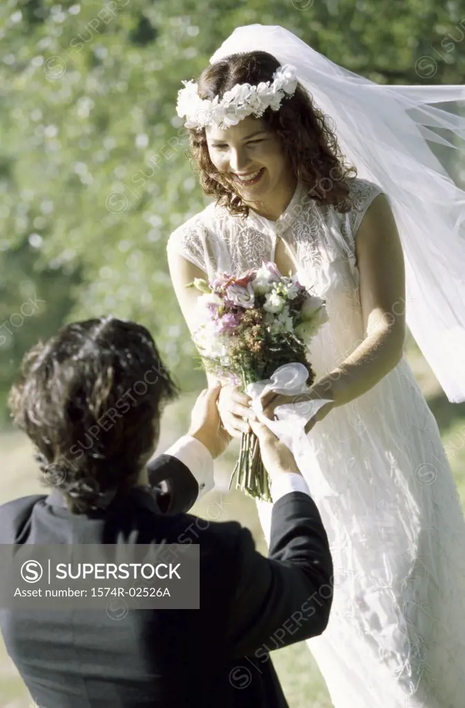 High angle view of a groom giving a bouquet of flowers to his bride