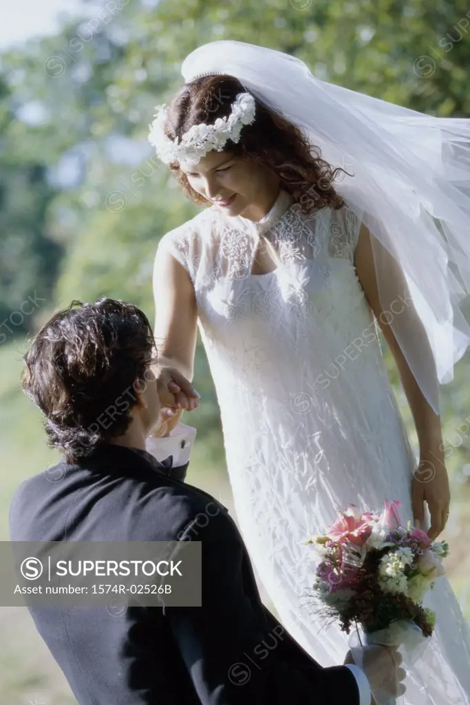 High angle view of a groom kissing his bride's hand