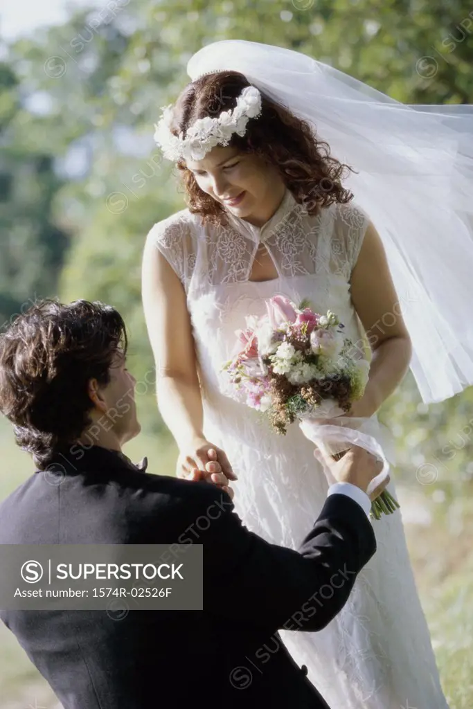 High angle view of a groom giving a bouquet of flowers to his bride