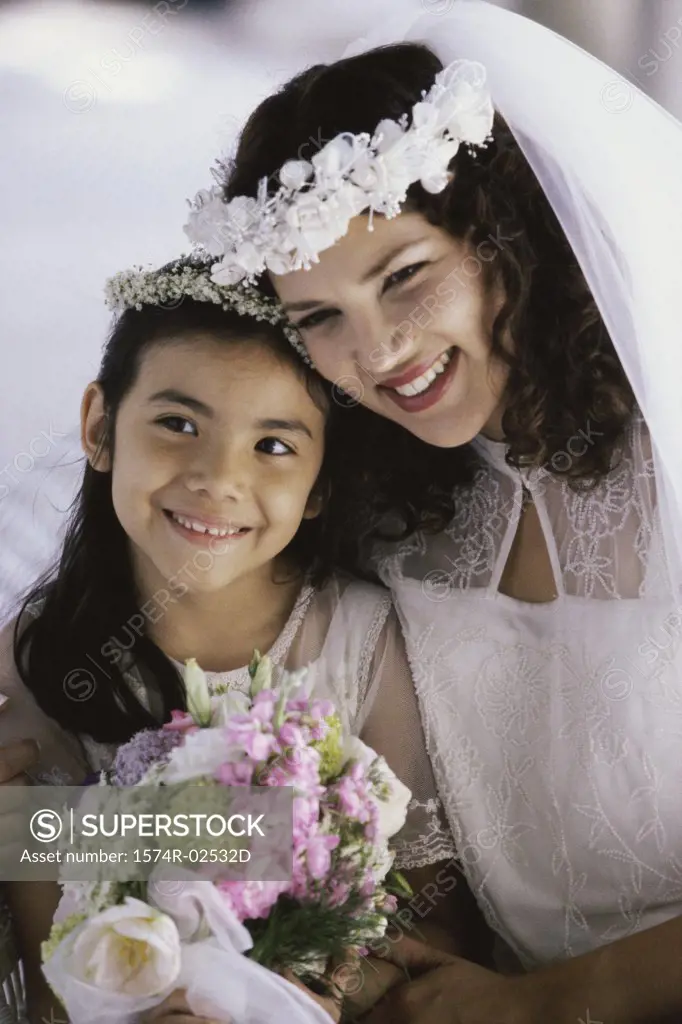 Close-up of a bride smiling with a flower girl