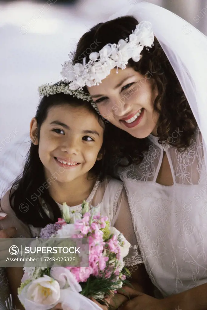 Close-up of a bride smiling with a flower girl