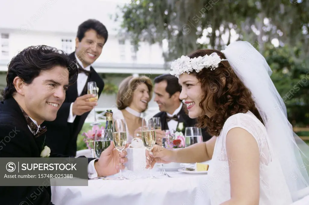 Newlywed couple and their friends toasting with champagne