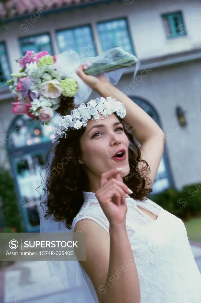 Newlywed young woman preparing to toss the bouquet