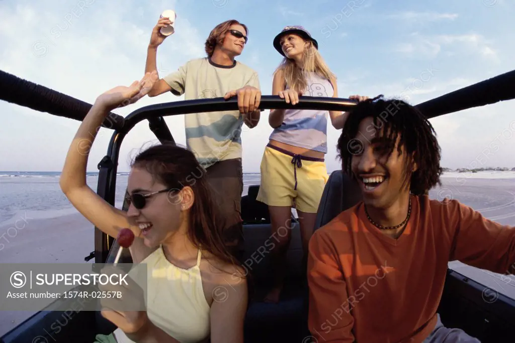 Low angle view of two young couples in a jeep