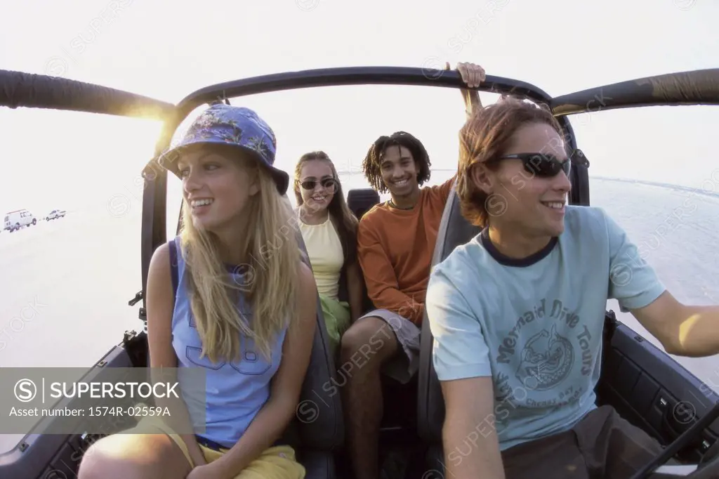 Two young couples sitting in a jeep