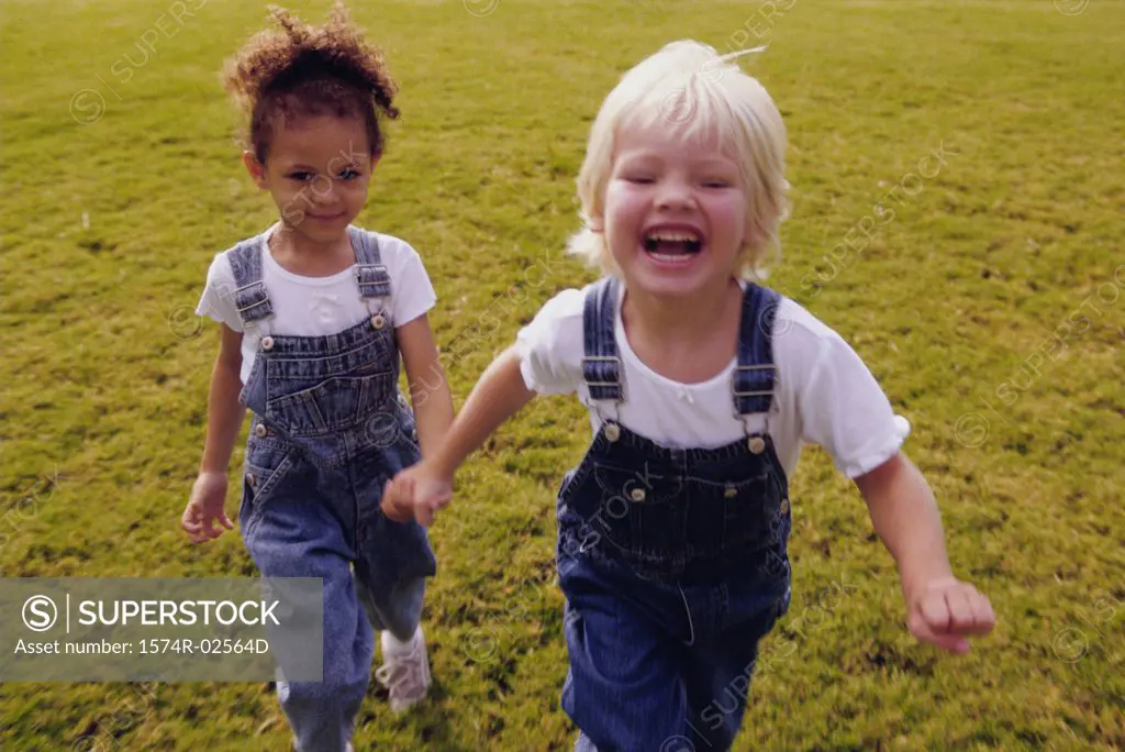 Two girls running on a lawn