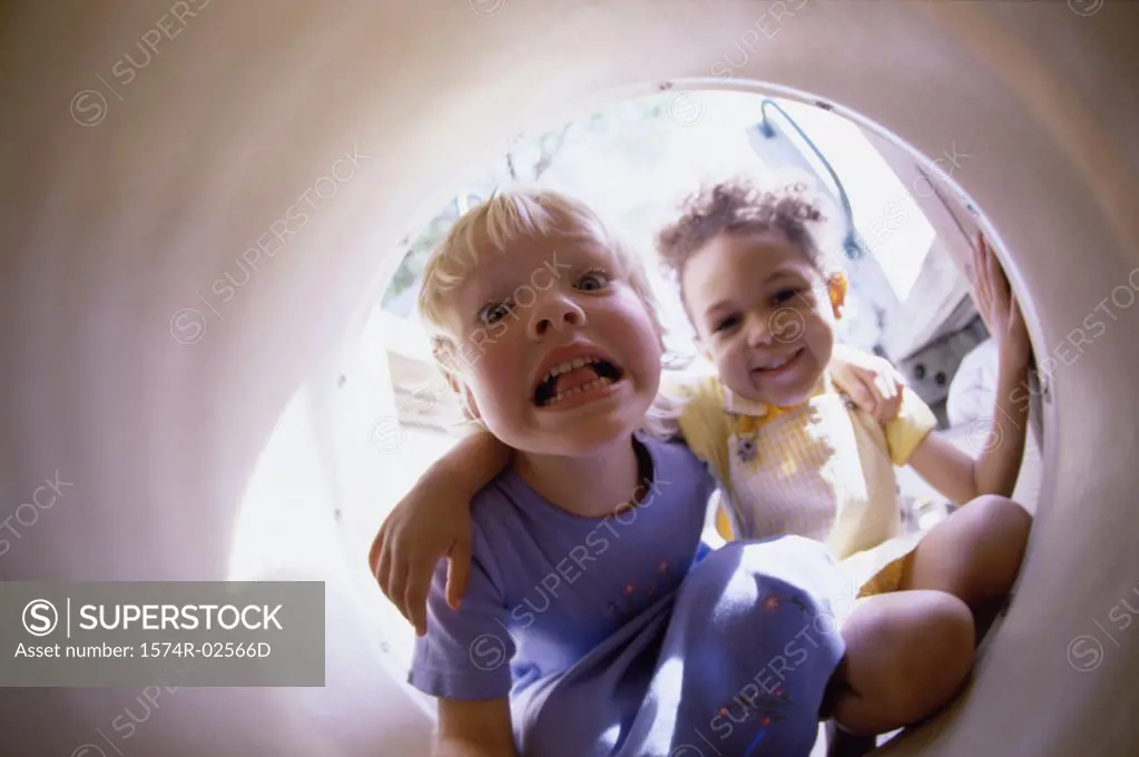 Portrait of two girls sitting in a tube
