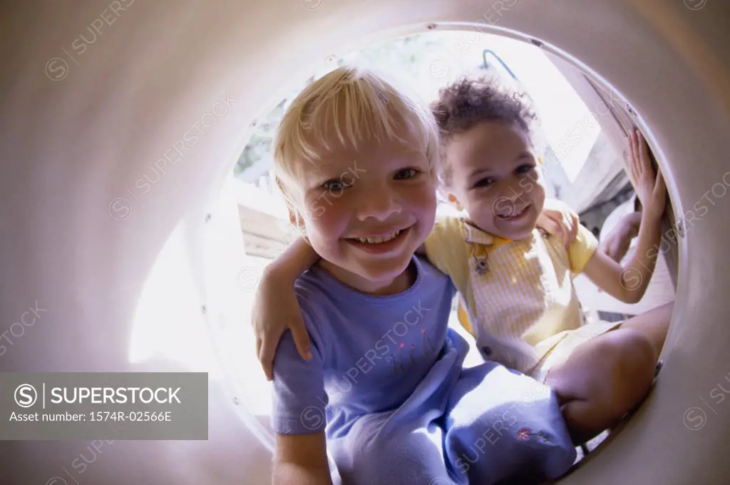 Portrait of two girls sitting in a tube