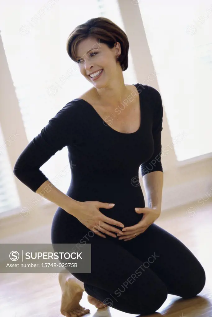 Portrait of a pregnant woman touching her abdomen