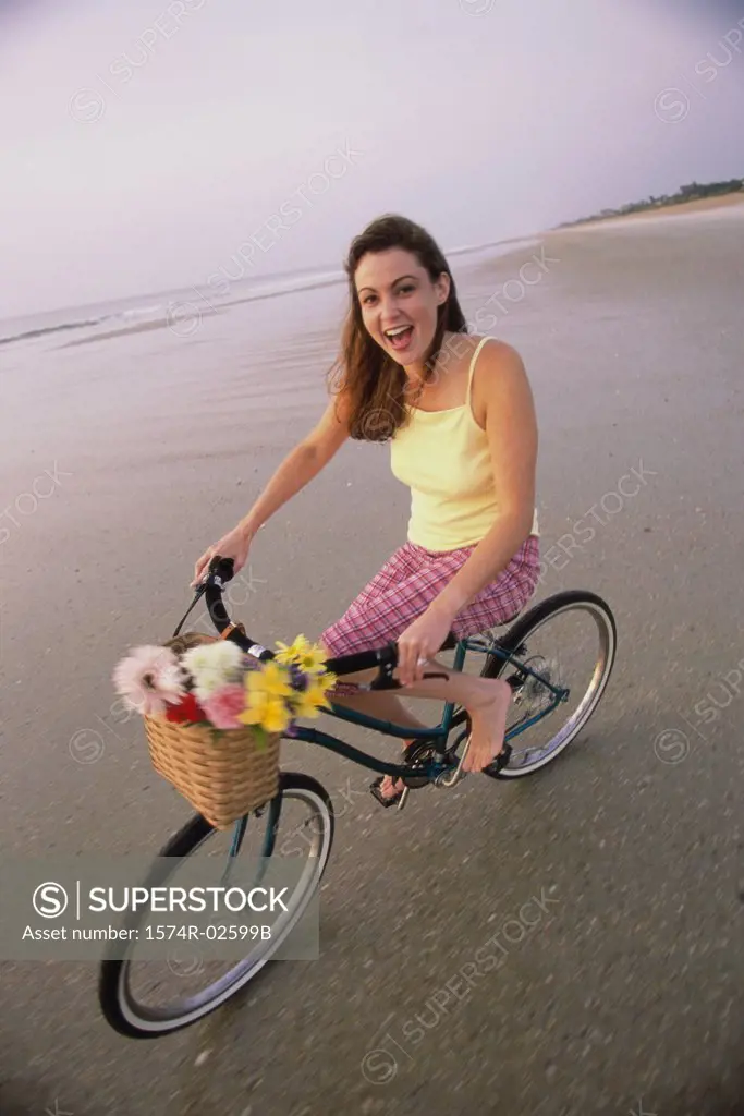 Portrait of a young woman cycling on the beach