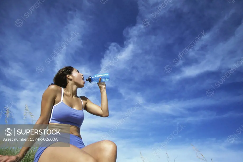 Low angle view of a young woman drinking water from a bottle