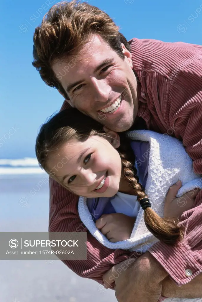 Father hugging his daughter on the beach