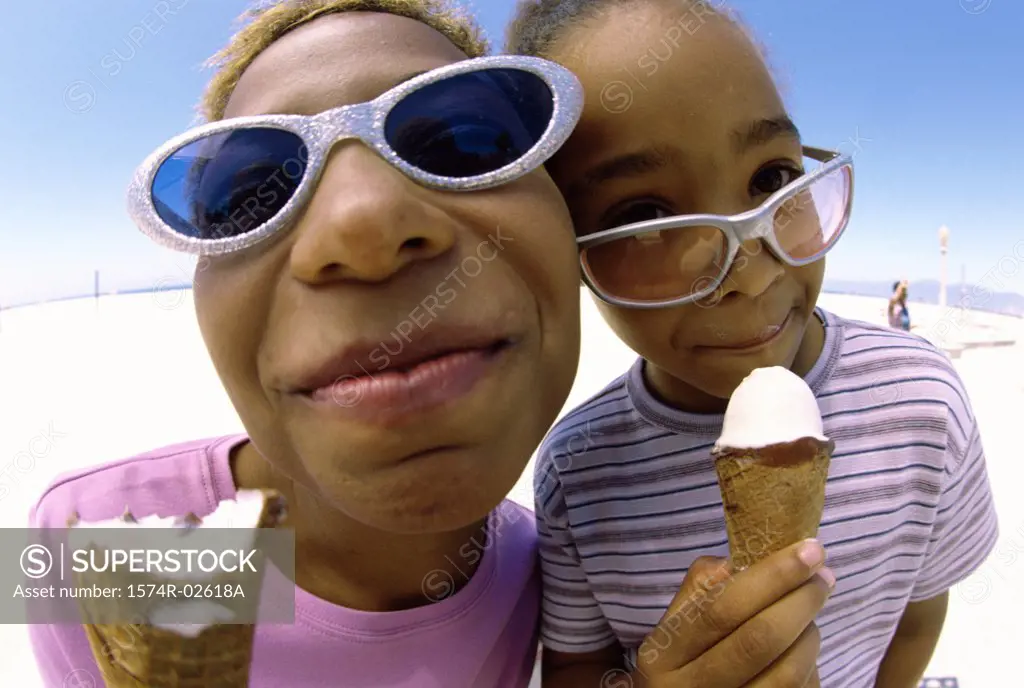 Close-up of a mother and her daughter holding ice cream cones