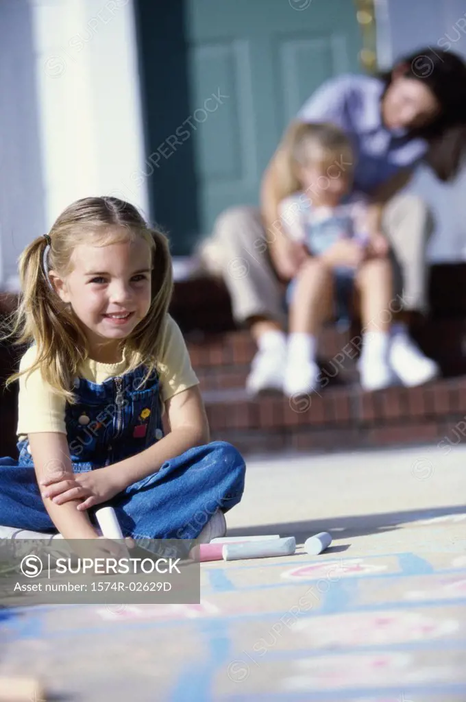 Portrait of a girl drawing on the floor with chalk