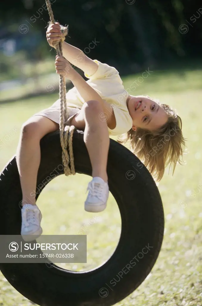 Portrait of a girl sitting on a tire swing