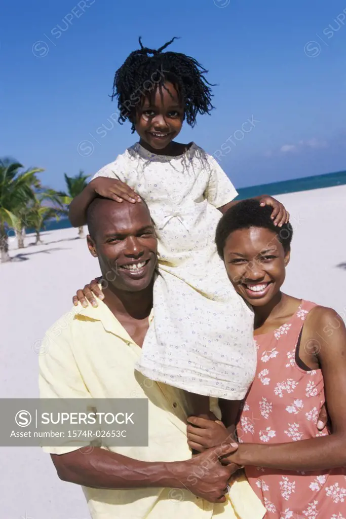 Portrait of parents carrying their daughter on their shoulders
