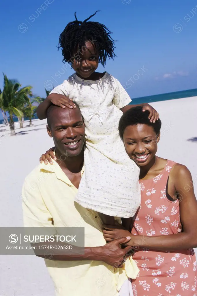 Portrait of parents carrying their daughter on their shoulders