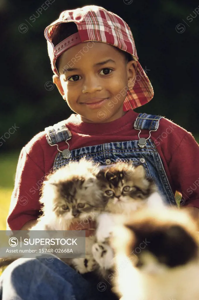 Close-up of a boy holding cats