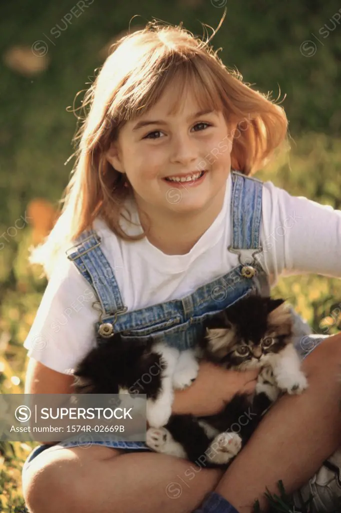 Portrait of a girl holding cats