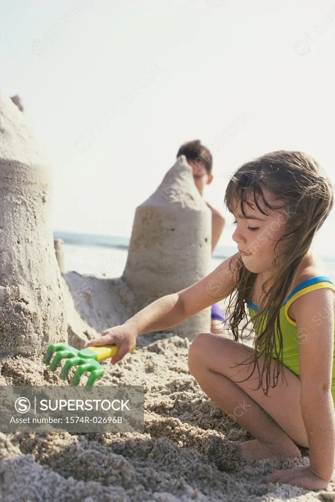 Boy and a girl making sand castles on the beach