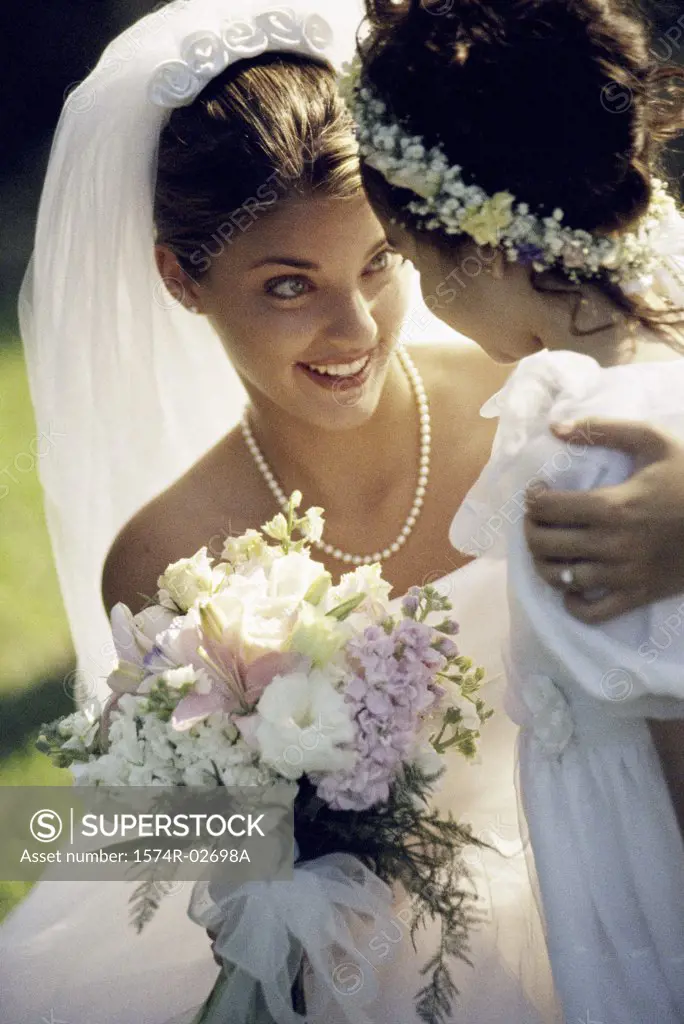 Close-up of a bride smiling at a flower girl