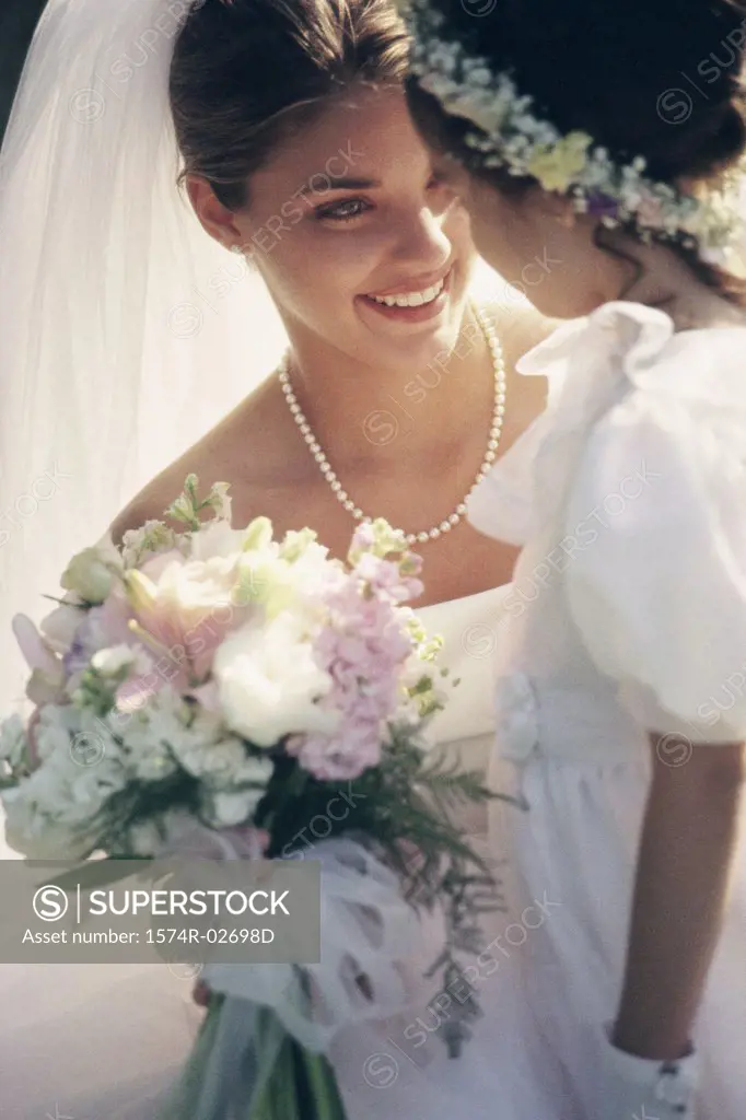 Close-up of a bride smiling at a flower girl