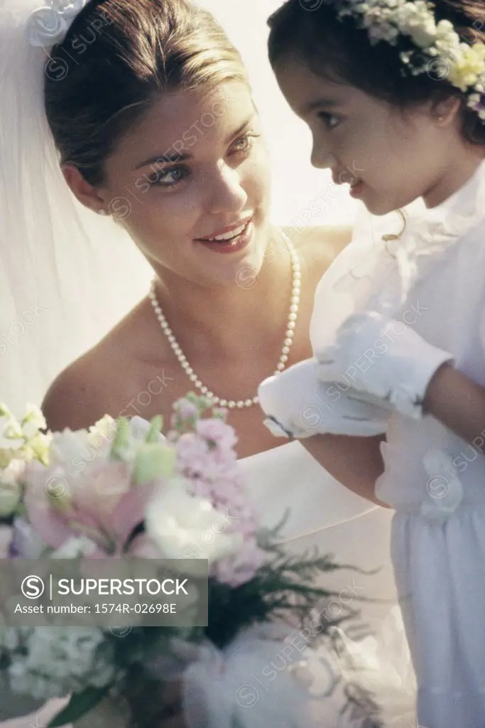 Bride and a flower girl talking to each other