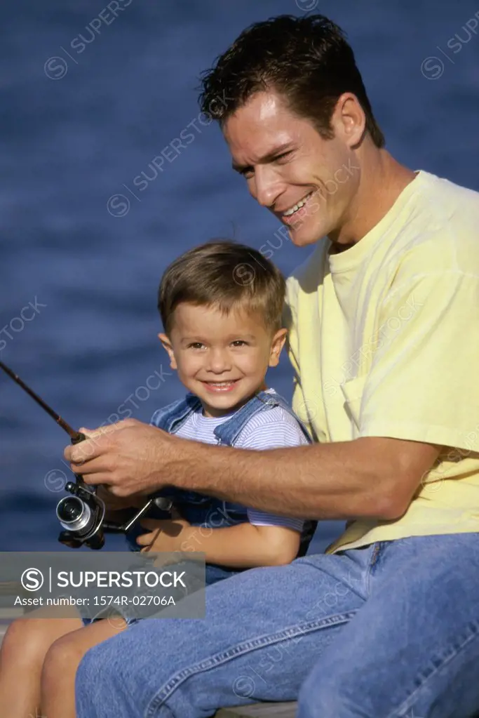 Close-up of a father teaching his son fishing