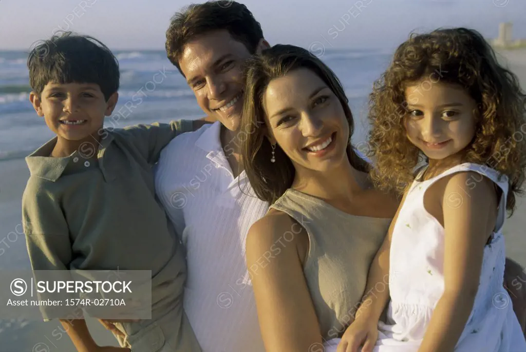 Parents holding their son and daughter on the beach