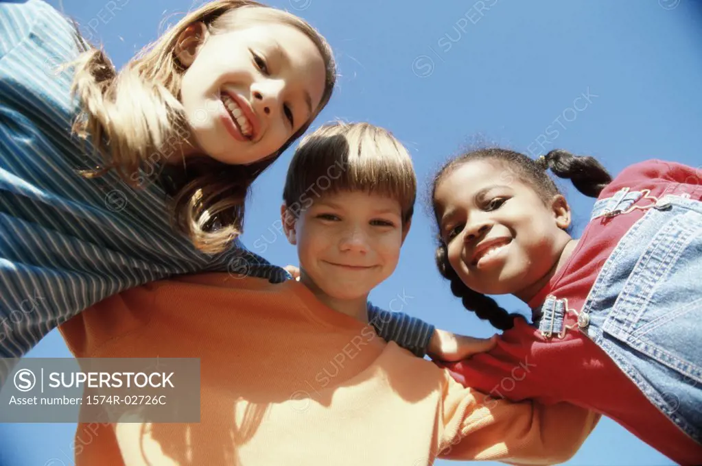 Close-up of two girls and a boy smiling