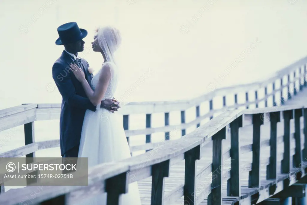 Newlywed couple embracing each other on a pier