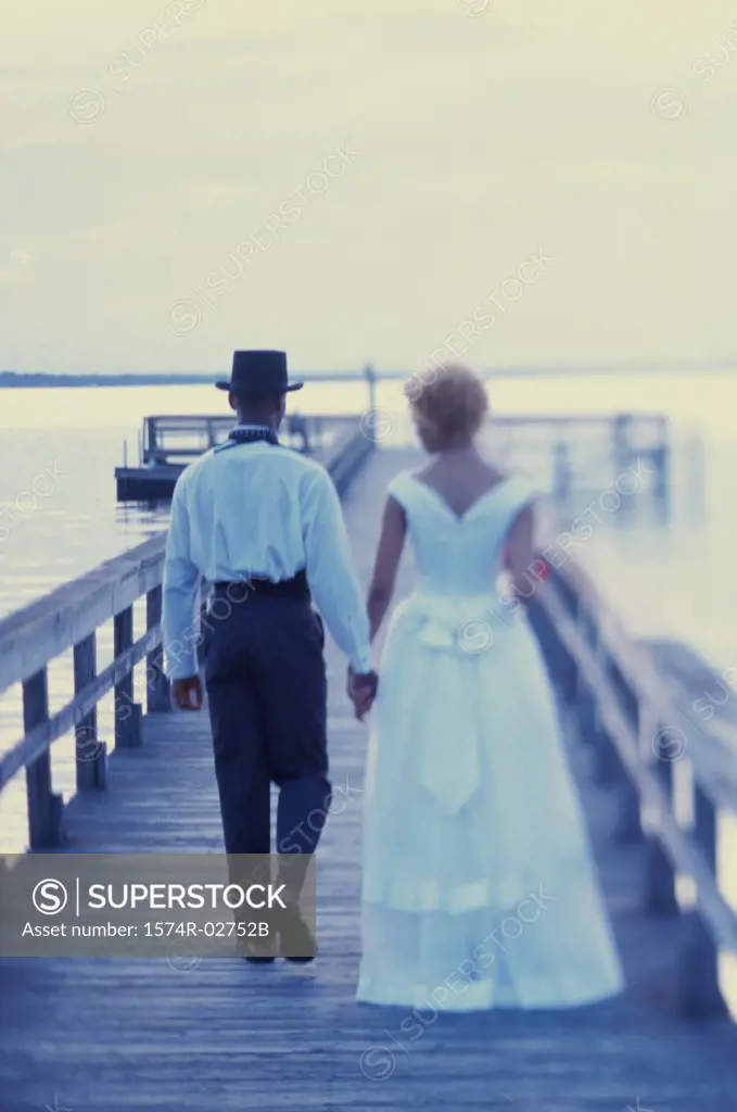 Newlywed couple walking on a pier