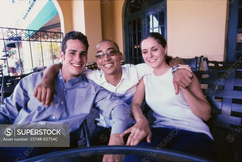 Portrait of two young men and a young woman smiling