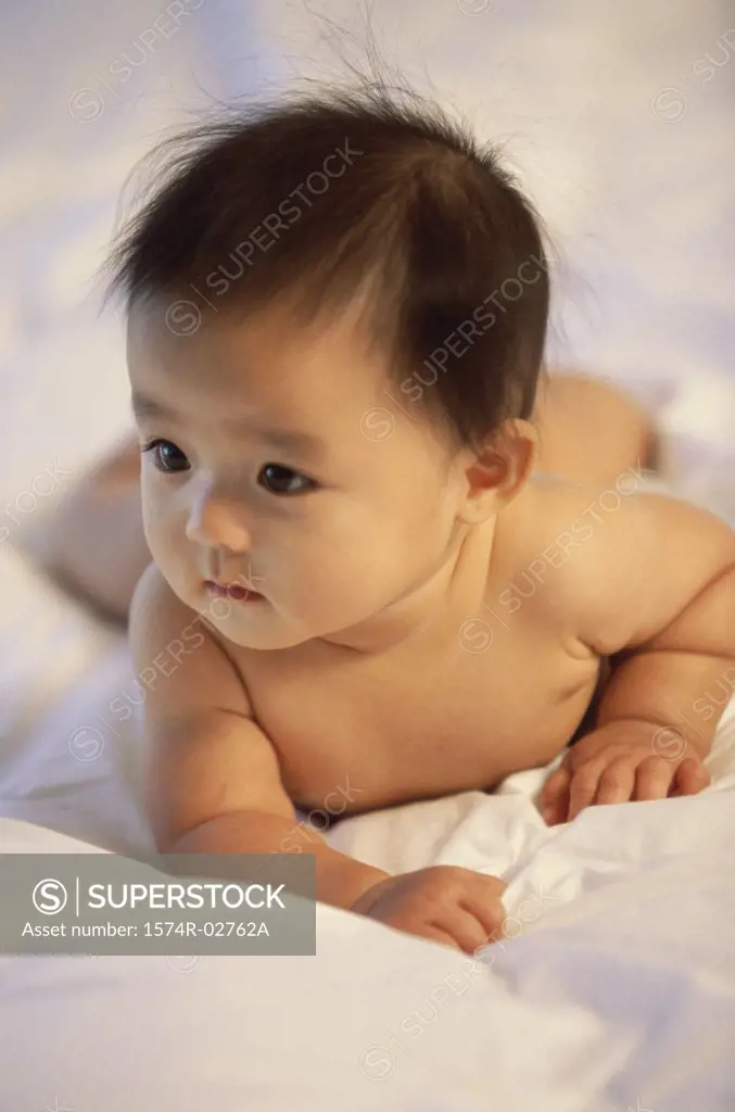 Close-up of a baby boy lying on a bed
