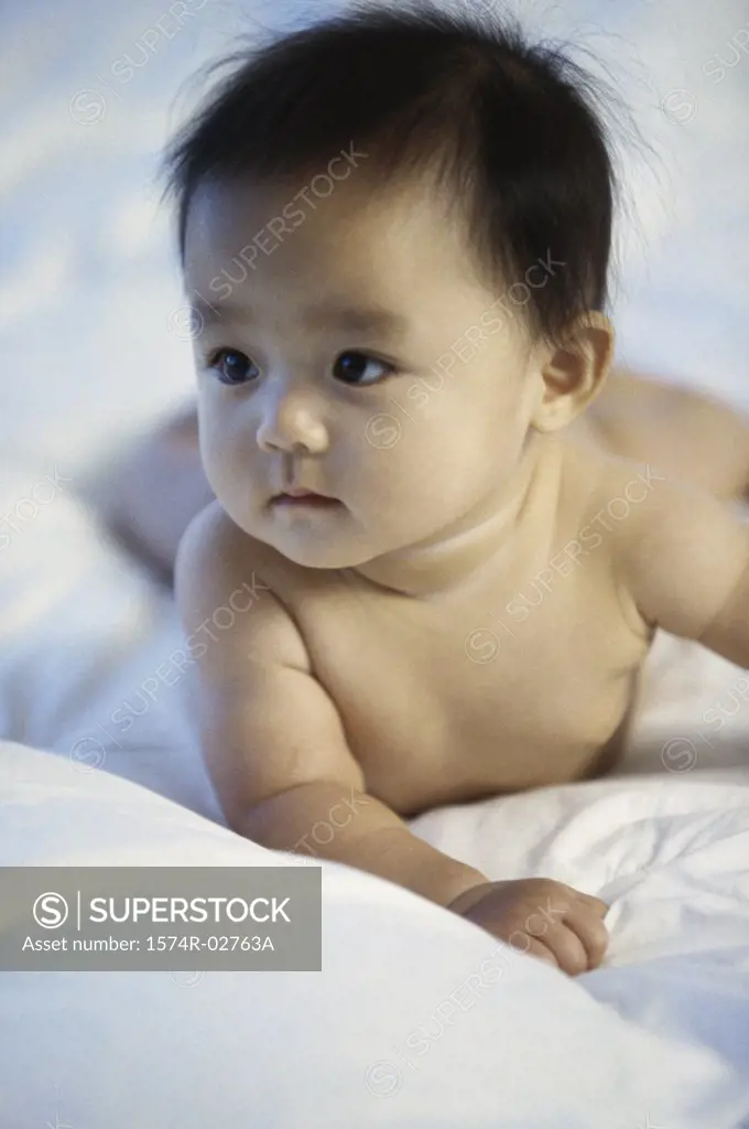 Close-up of a baby boy lying on a bed